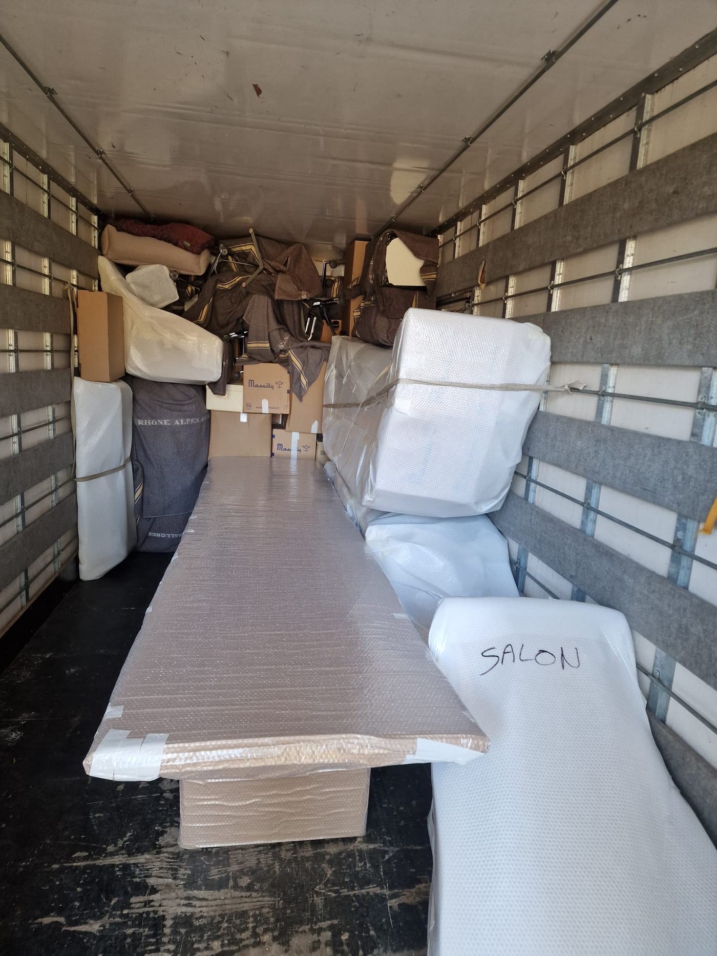 Camion de déménagement chargé et organisé, cartons et meubles protégés