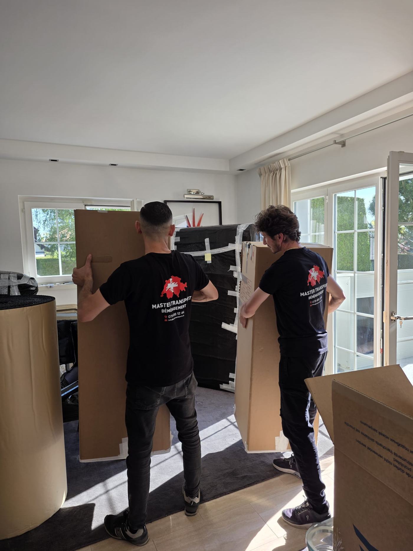 Déménageurs transportant des cartons emballés à l'intérieur d'un logement