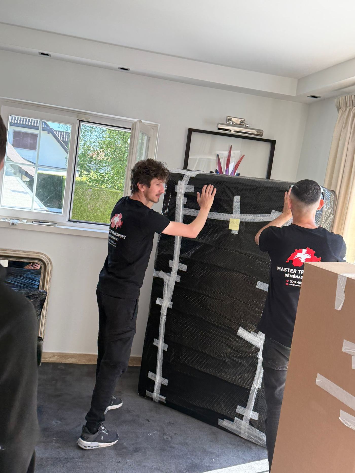 Équipe Master Transport Déménagement emballant un meuble fragile
